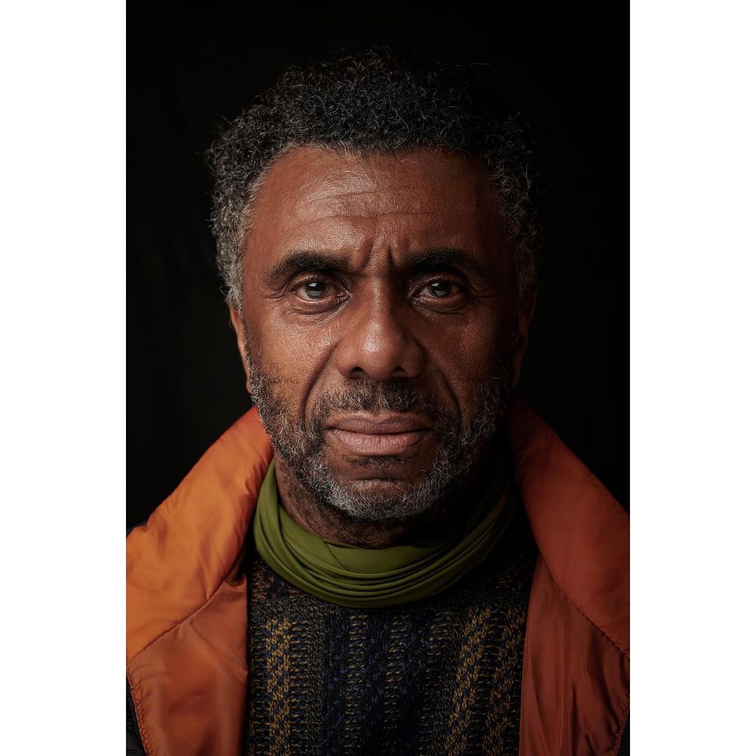Headshot of a middle-aged Black man with salt-and-pepper hair looking directly at the camera with a neutral expression, wearing casual clothing.