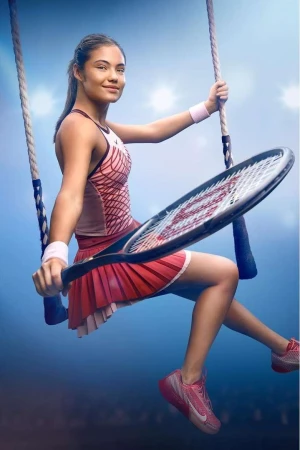 A tennis player is sitting on a swing holding a racket and wearing tennis apparel in front of a blue background with lights.