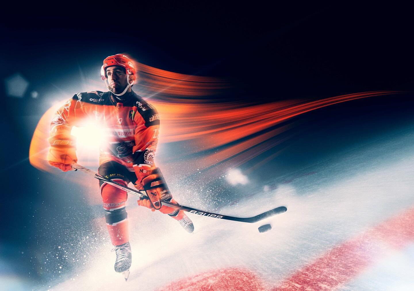 Dynamic action shot of a hockey player in orange uniform skating on ice with streaks of light and motion blur. Sport and energy.