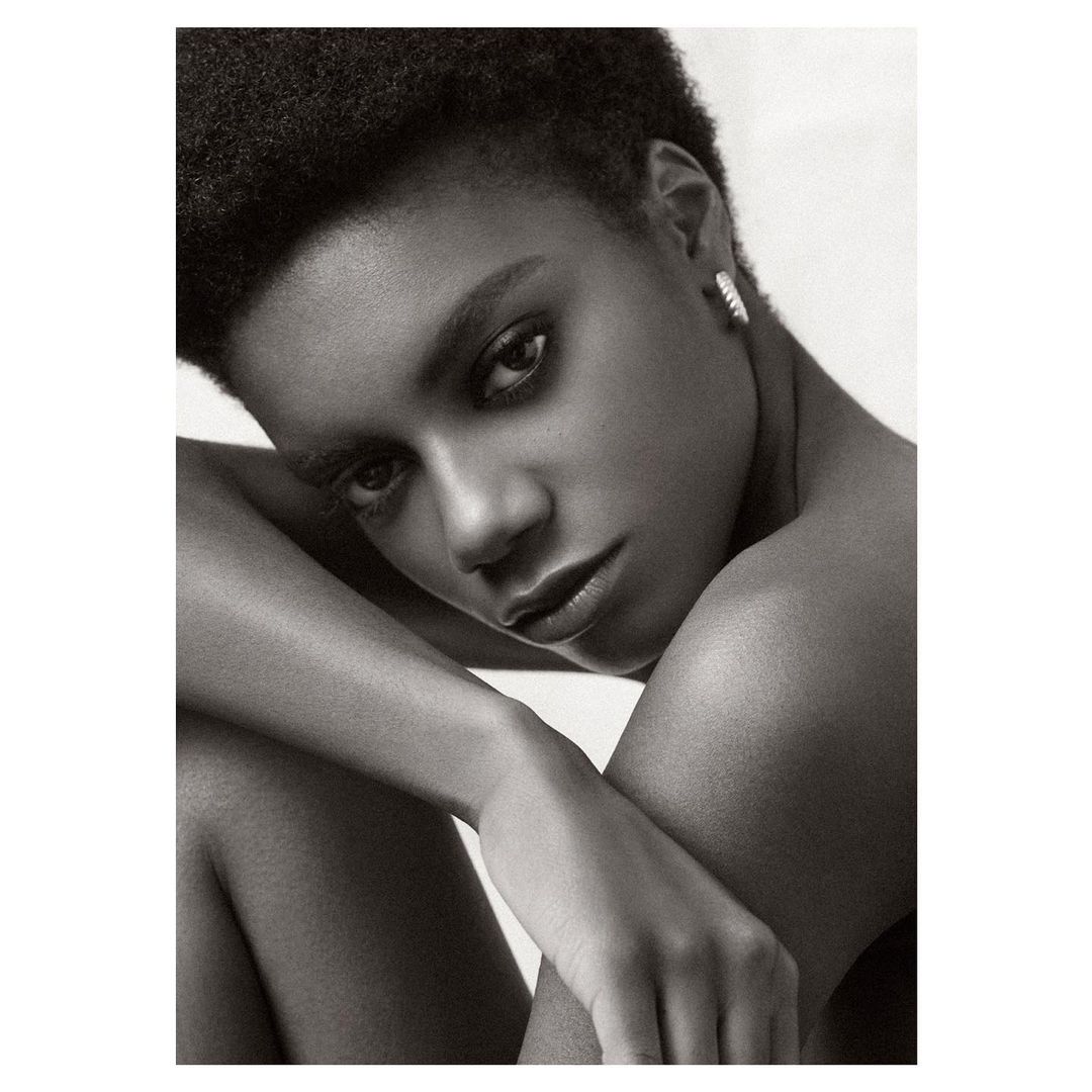 Close-up monochrome portrait of a Black woman with short dark hair and a serious expression by photographer Nick Eucker.
