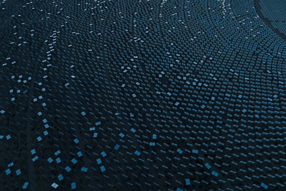 Aerial view of a large-scale solar power plant with neatly arranged dark photovoltaic panels against a dark terrain, generating clean energy.