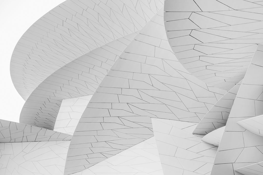 Monochromatic architectural shot of an angular building exterior featuring geometric patterns and textured surface in abstract composition.