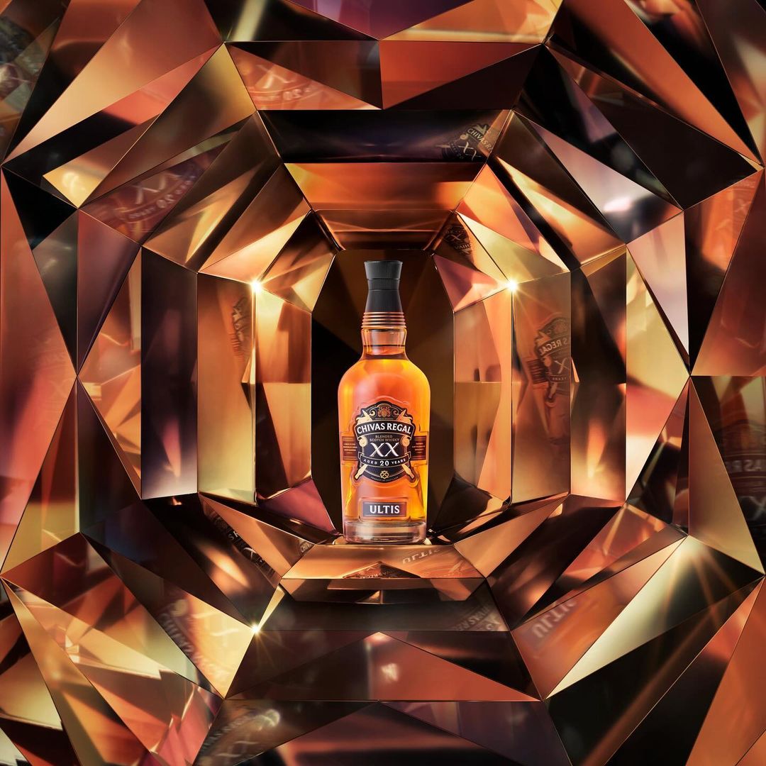 Chivas Regal whisky bottle on display in front of a reflective diamond patterned background, product shot, luxury brand.
