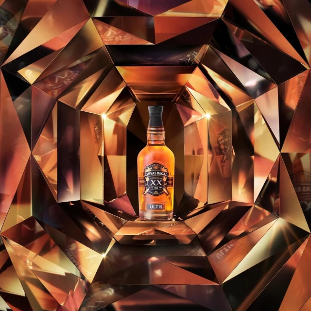 Chivas Regal whisky bottle on display in front of a reflective diamond patterned background, product shot, luxury brand.