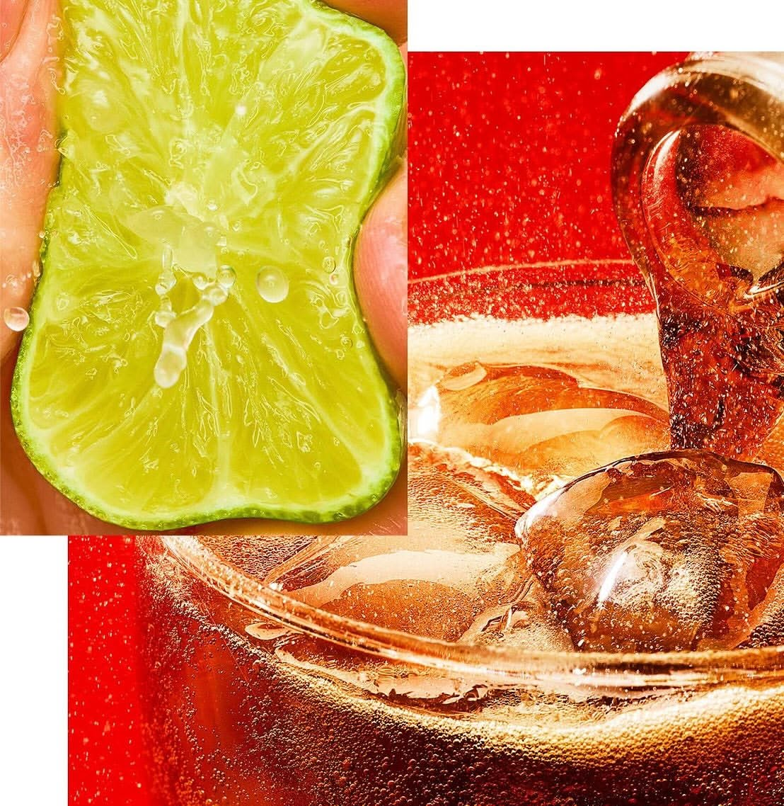Close-up of a glass with a brown beverage, ice cubes, and bubbles, accompanied by a hand squeezing a fresh lime wedge.