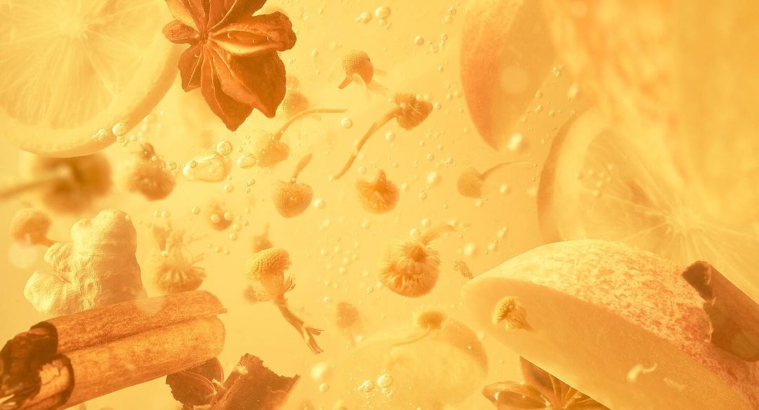 Aromatic herbal tea featuring ginger, lemon, cinnamon, and chamomile infuses golden liquid with bubbles, creating a soothing, flavorful blend.