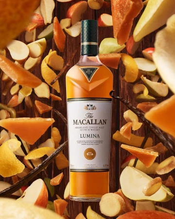 The Macallan Lumina single malt scotch whisky bottle centered amid floating fruit pieces and spices by Nick Rees