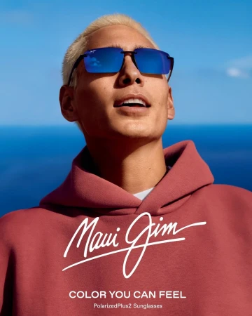 Close-up portrait of a man wearing blue mirrored sunglasses and a dusty rose hoodie against an ocean background by Nick Riley Bentham