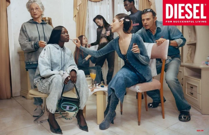 A group of diverse people in denim clothing gather indoors for a makeup session, featuring Diesel branding, warm lighting, and casual style.