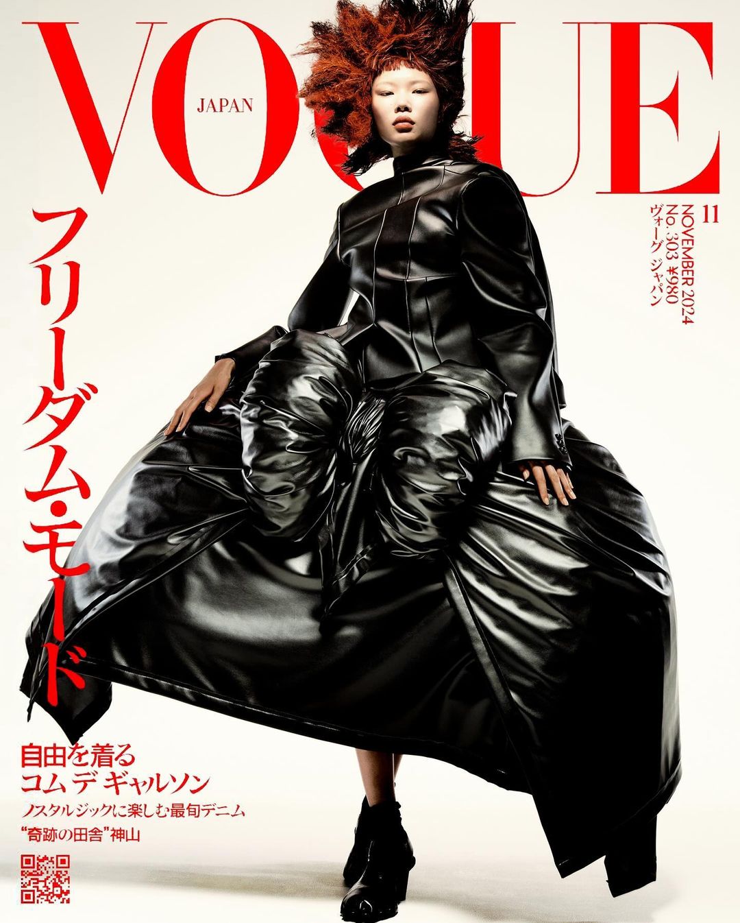 Vogue Japan cover featuring a model in a dramatic black avant-garde dress with a large sculptural skirt and spiky red and black hair.