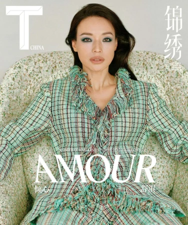 Fashion magazine cover featuring an adult female model in a plaid suit with fringe detail, seated on a patterned armchair with magazine logos and titles.