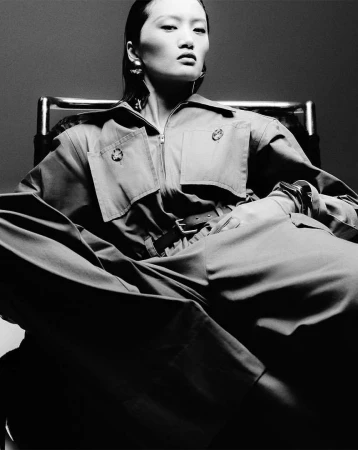 Model seated in an armchair wearing a utility jumpsuit in Paris by Nick Yang