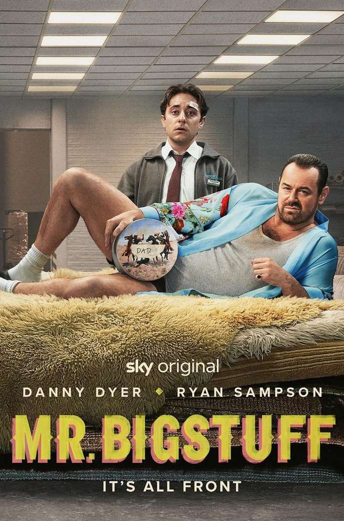 Promotional image for 'Mr. Bigstuff' features Danny Dyer reclining on a furry bed, holding a round object, with Ryan Sampson standing behind.