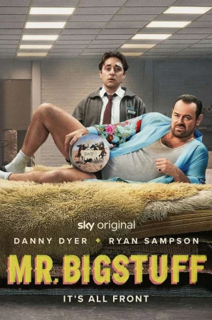 Promotional image for 'Mr. Bigstuff' features Danny Dyer reclining on a furry bed, holding a round object, with Ryan Sampson standing behind.