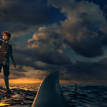 A boy is stranded on a rock surrounded by ocean waters with a shark fin visible. Dark, cloudy sky with a sliver of light on the horizon.
