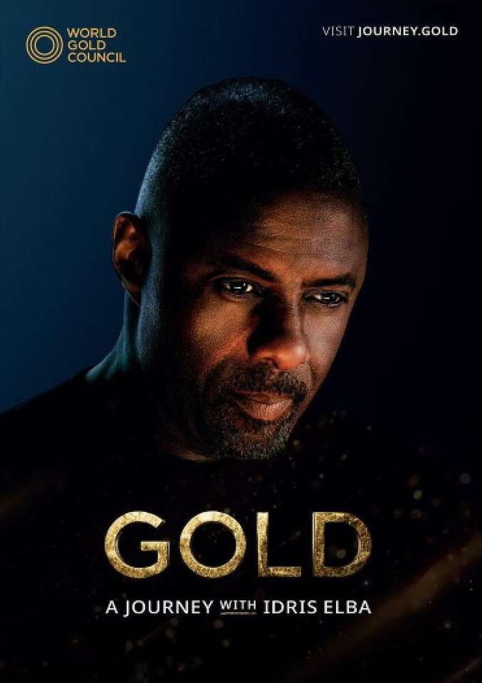 Close-up portrait of Idris Elba with gold lettering and gold council logo on a dark blue background for a World Gold Council advertisement.
