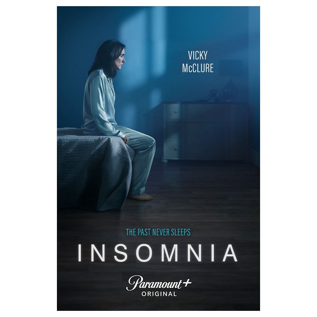 Vicky McClure sits on a bed in a dimly lit room in a promo image for Paramount+'s INSOMNIA. The text on the image reads, 'INSOMNIA'.