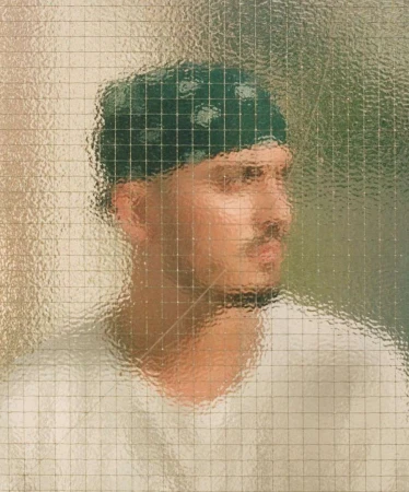 Portrait of a man with a mustache and a green bandana looking away, partially obscured by a textured glass panel. 