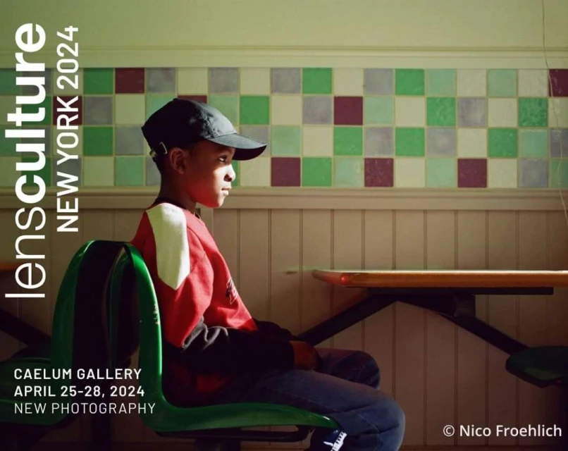 Portrait of a young African-American boy seated in a green chair against a tiled wall for an exhibition poster in New York, 2024.