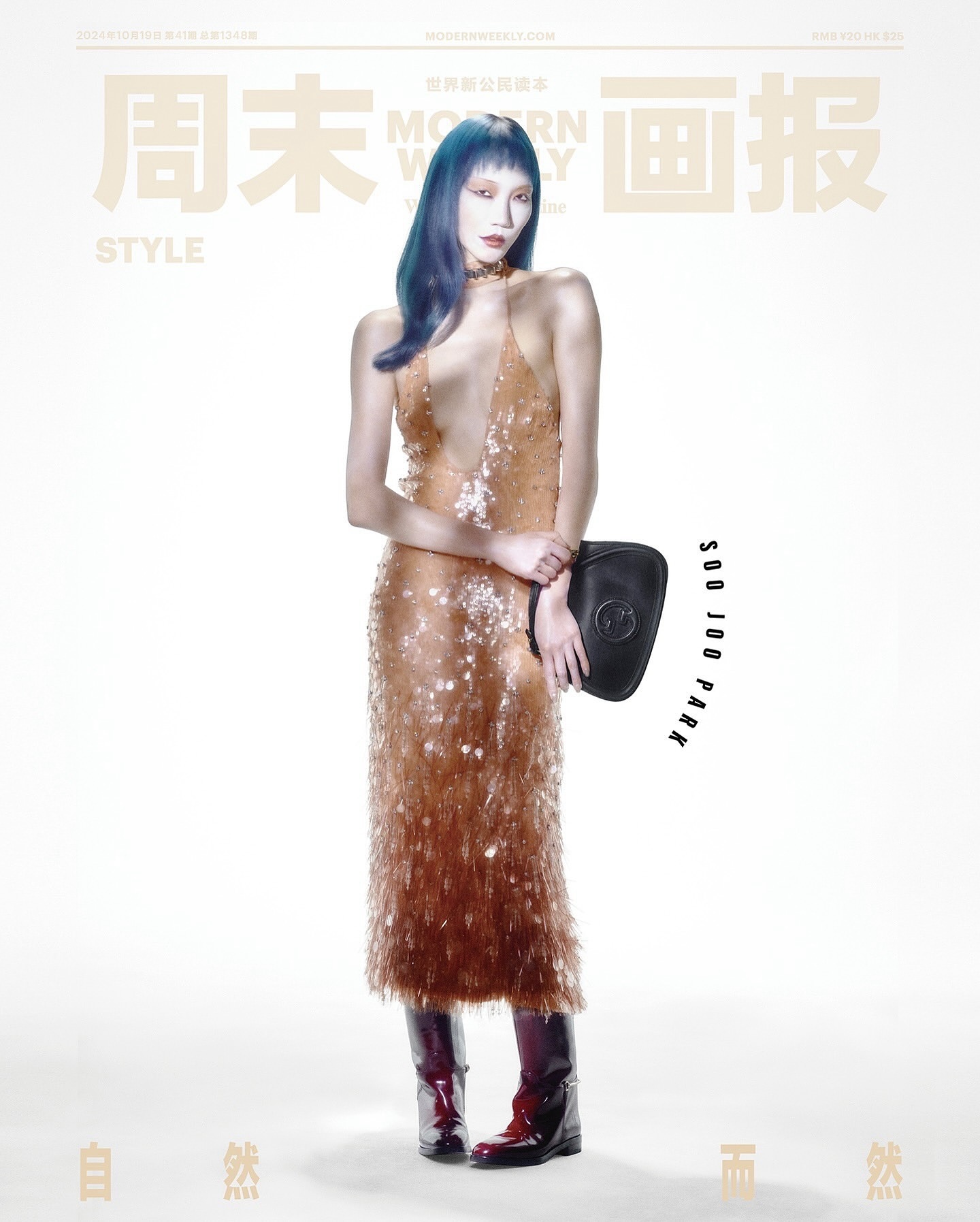 Editorial fashion shot of a woman with blue hair wearing a sequined gown and carrying a black bag in a bright, high-key studio setting.