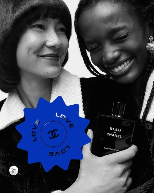 Two women pose in a black and white shot with a Chanel perfume bottle. The backdrop is minimalist, and a blue starburst adds color.