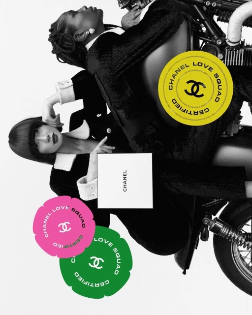 Two women in black-and-white outfits pose with a motorcycle and Chanel accessories against a white background in a fashion shot.