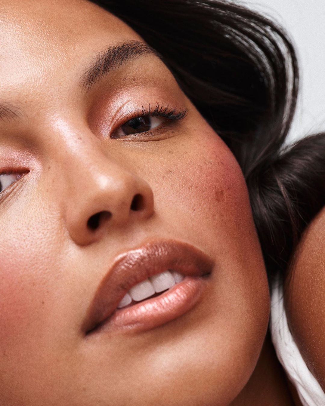 Extreme close-up beauty portrait of a woman with glossy lips and subtle freckles by photographer Nicolas Kantor.