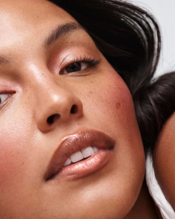Extreme close-up beauty portrait of a woman with glossy lips and subtle freckles by photographer Nicolas Kantor.