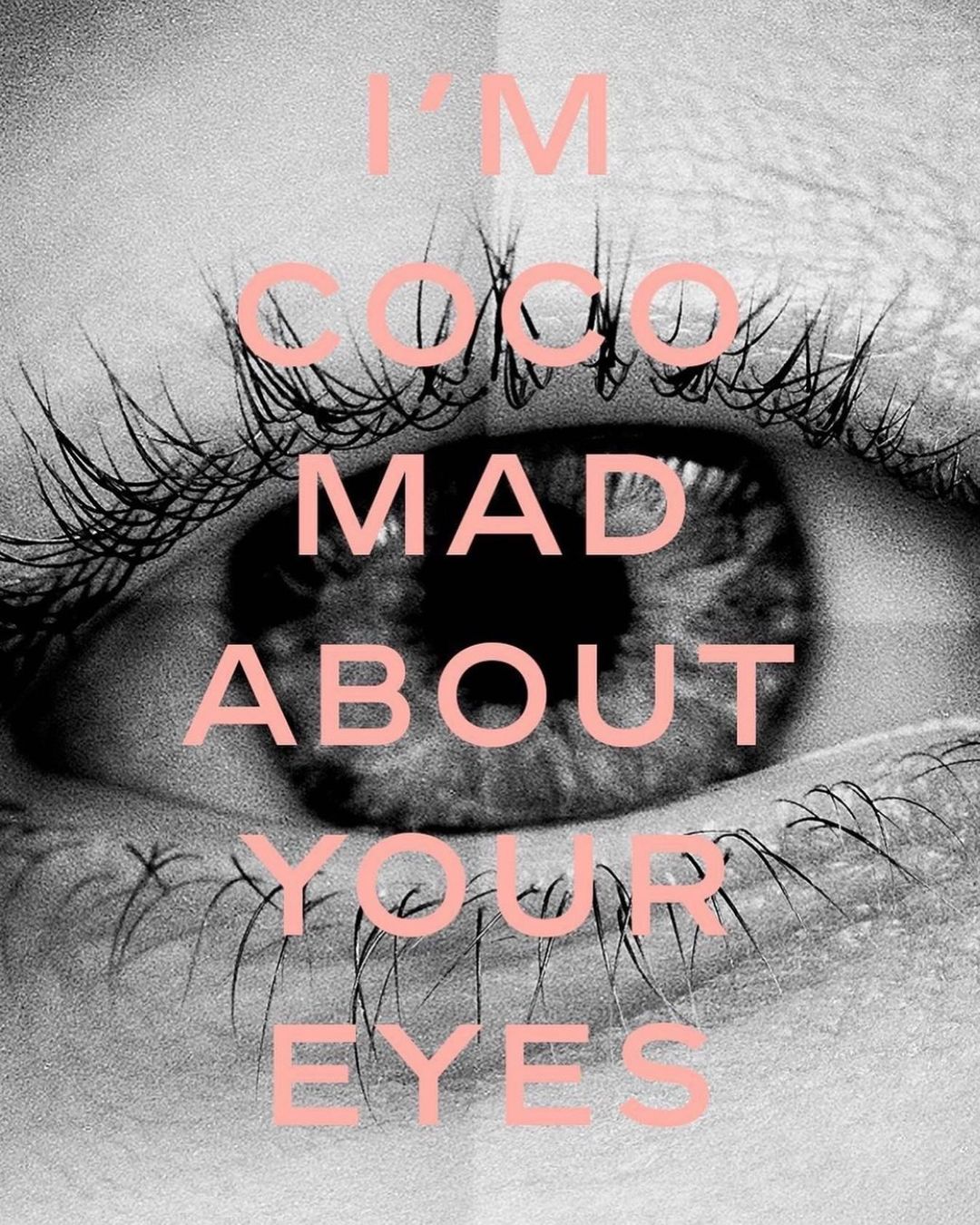 Close-up of a human eye with long eyelashes, featuring overlaid pink text 'I'm Coco mad about your eyes' on a black and white background.