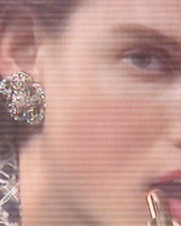 Close-up on a woman's face with an earring, showing a portion of her face including her eye, cheek, ear, and part of her mouth.