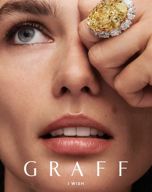 Close-up beauty shot of a fair-skinned female with light blue eyes wearing yellow diamond jewelry from GRAFF jewelry collection.
