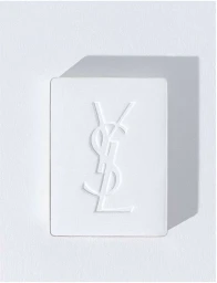 White cosmetic powder compact case featuring an embossed interlocking YSL logo on a textured white paper background