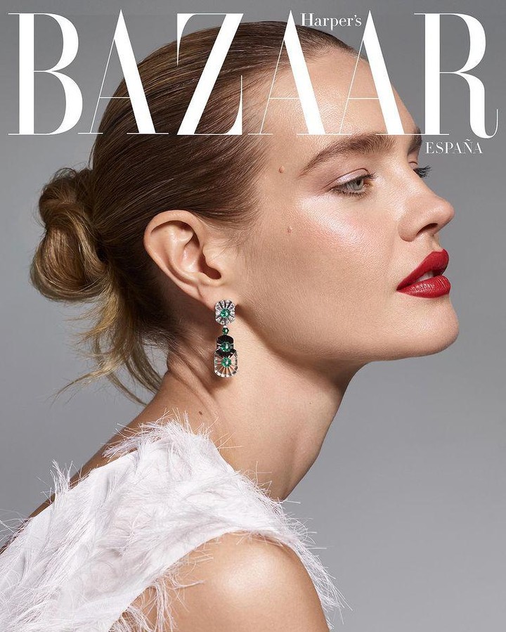 Magazine cover featuring a woman with red lipstick and a feathered top, against a grey backdrop with the 'Bazaar' logo.