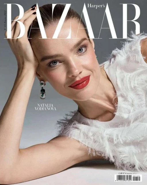 Natalia Vodianova gazes at the camera on a Harper's Bazaar magazine cover, adorned with Bazaar masthead and a white feathered top.