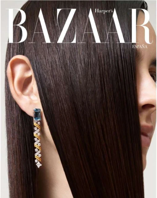 Close-up beauty shot of adult female with shiny dark hair, jewelry earring, partial face view in a photo studio setting with bright lighting.