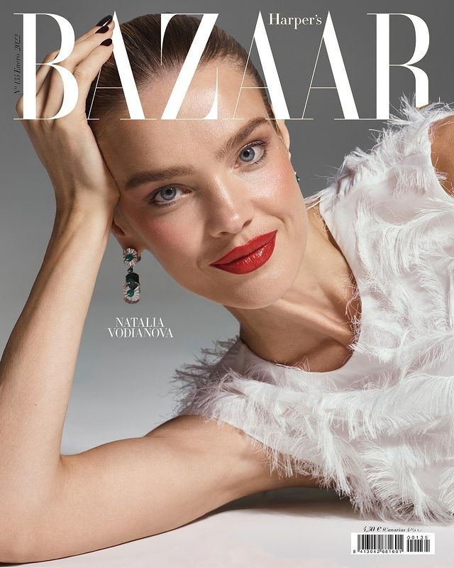 Natalia Vodianova on Harper's Bazaar cover featuring close-up of the model with red lips, white feathered top, and statement earrings.