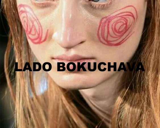Close-up of a person with drawn red spiral blush on their cheeks and black text overlay reading Lado Bokuchava.