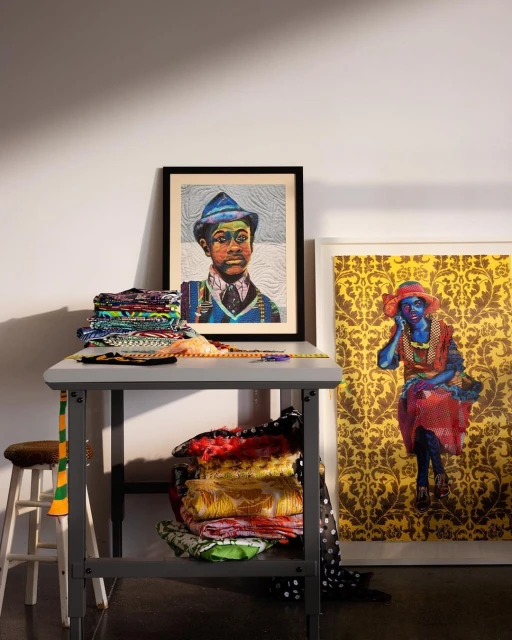 Interior studio shot of a table with a portrait and folded textile art, featuring vibrant colors and a mix of patterns.
