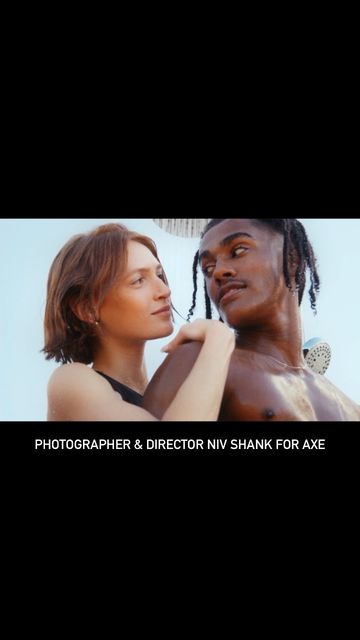 Attractive couple poses in an outdoor shower. The fair-skinned woman stands to the left of the dark-skinned man. Fashion, beauty and lifestyle.