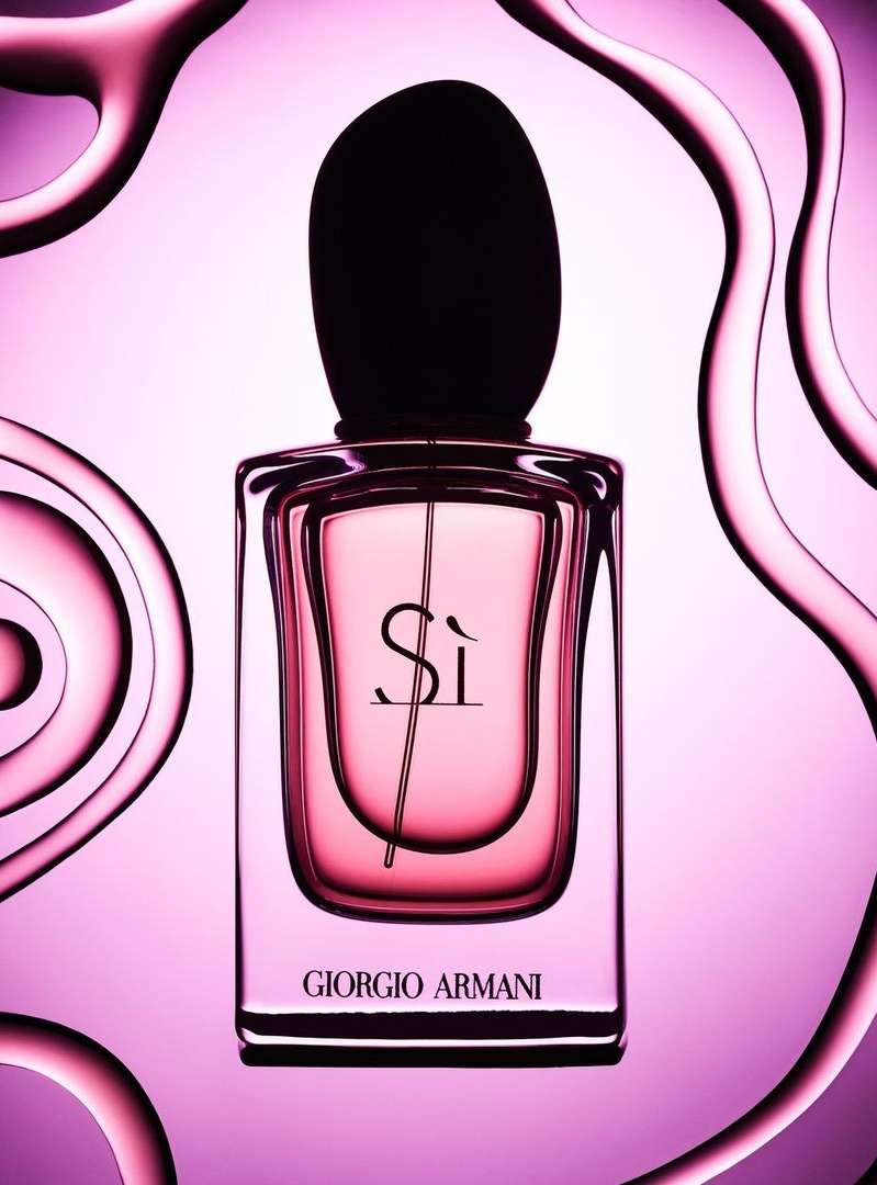 Giorgio Armani Sì perfume bottle on a light purple background with pink liquid swirls, studio shot, beauty and cosmetics product.