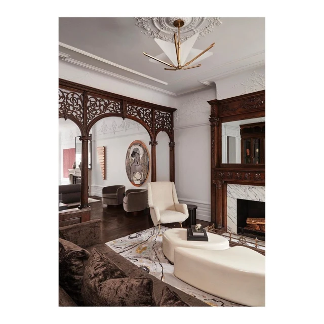 Luxurious living room interior featuring a brown velvet sofa, cream-colored seating, ornate woodwork, decorative fireplace, and modern lighting.