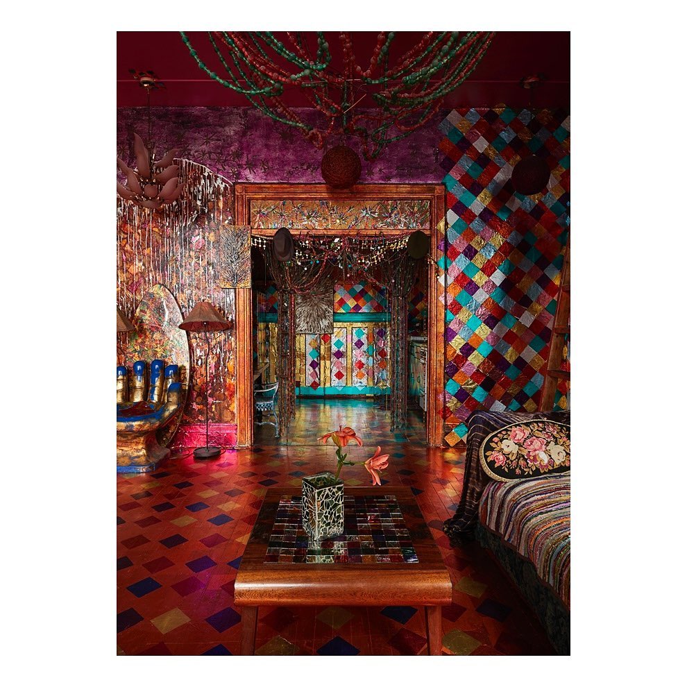 Opulent interior of a colorful room showcasing a vibrant mix of textures, patterns, and decorative elements in a home setting.