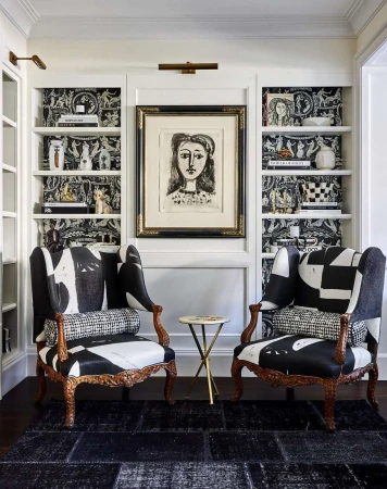 Interior design with two black-and-white patterned armchairs, a side table, and a wall unit with shelves and artwork in a home setting.