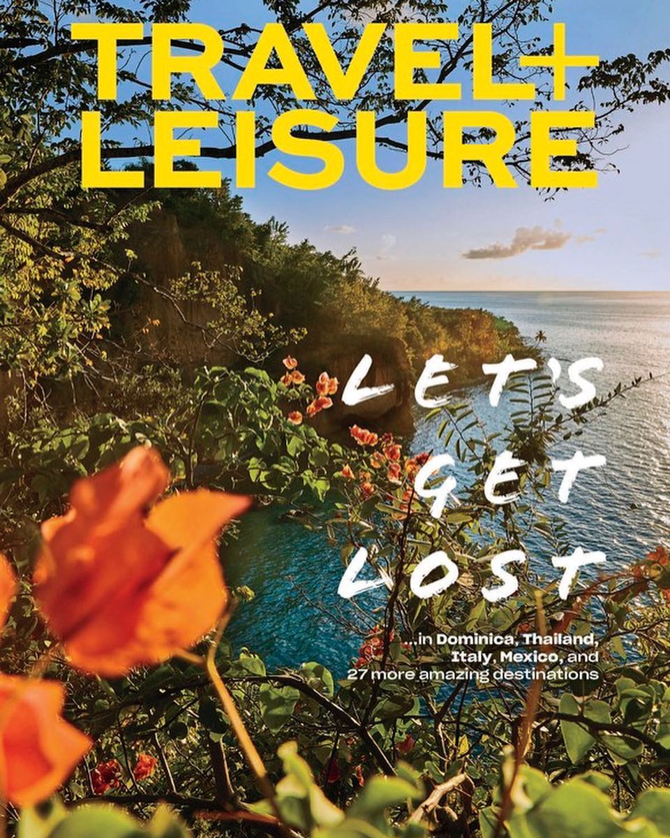 Travel + Leisure magazine cover featuring a lush tropical scene with ocean views and bold yellow typography, inviting exploration.