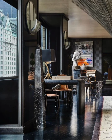 Elegant interior featuring modern furnishings, a textured desk, and a view of a city skyline through a large window.