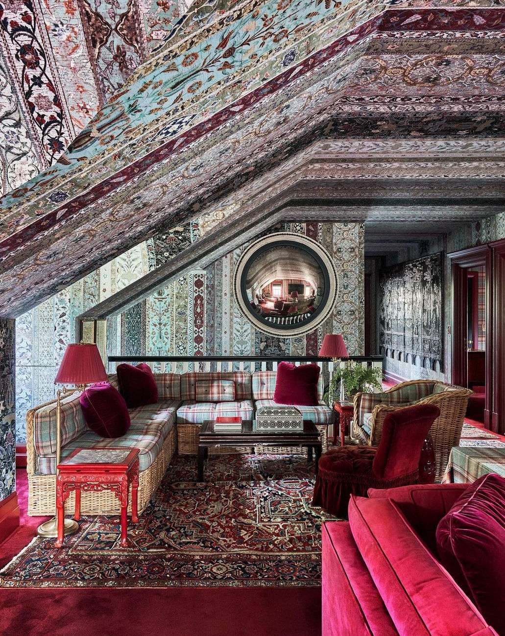 Ornate interior with patterned walls and ceiling, featuring a wicker sofa, coffee table, and rug, creating a visually rich home setting.