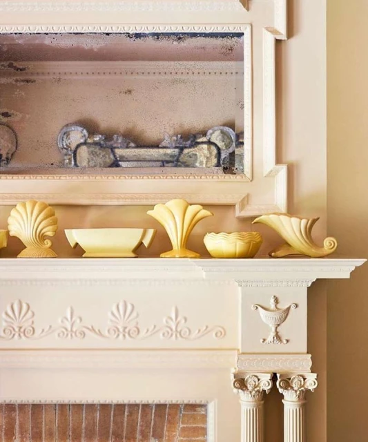 A mantelpiece is decorated with decorative objects including ceramic vases and a mirror, creating a classic and elegant display.