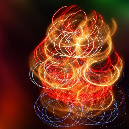 Abstract swirl of red, orange, and white light trails against a dark background, created with long exposure photography.