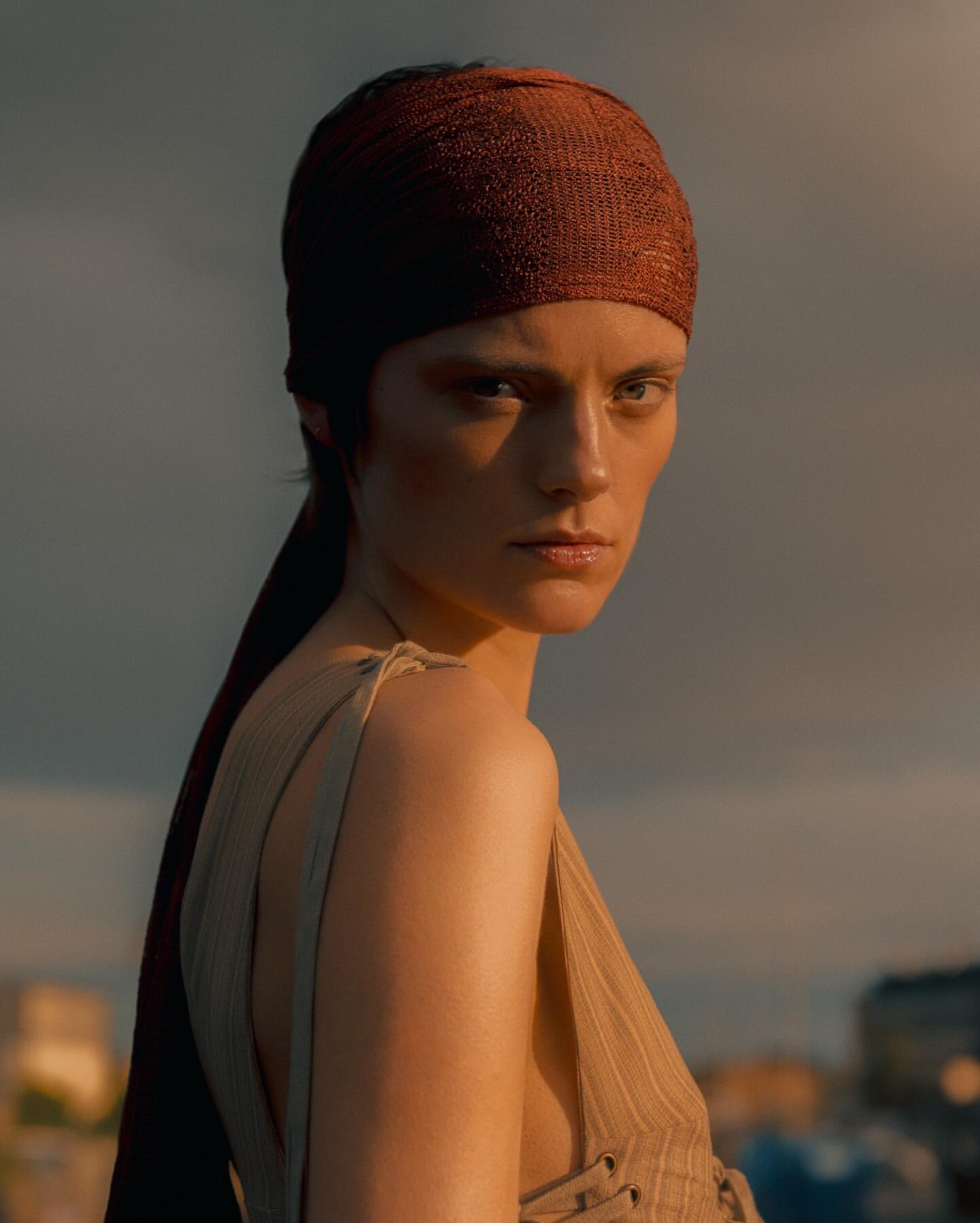 Portrait of a model wearing a rust-colored headscarf and a beige top in Paris by Noemi Ottilia Szabo.