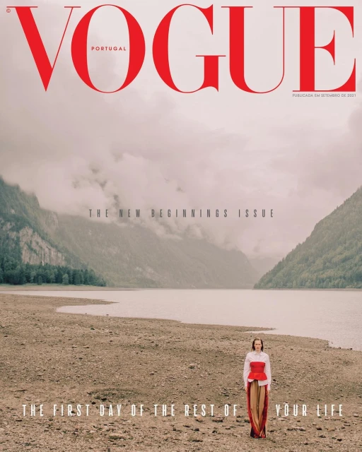 Vogue Portugal cover featuring a woman standing on a rocky shore with a lake and mountains in the background, under the 'New Beginnings' theme.